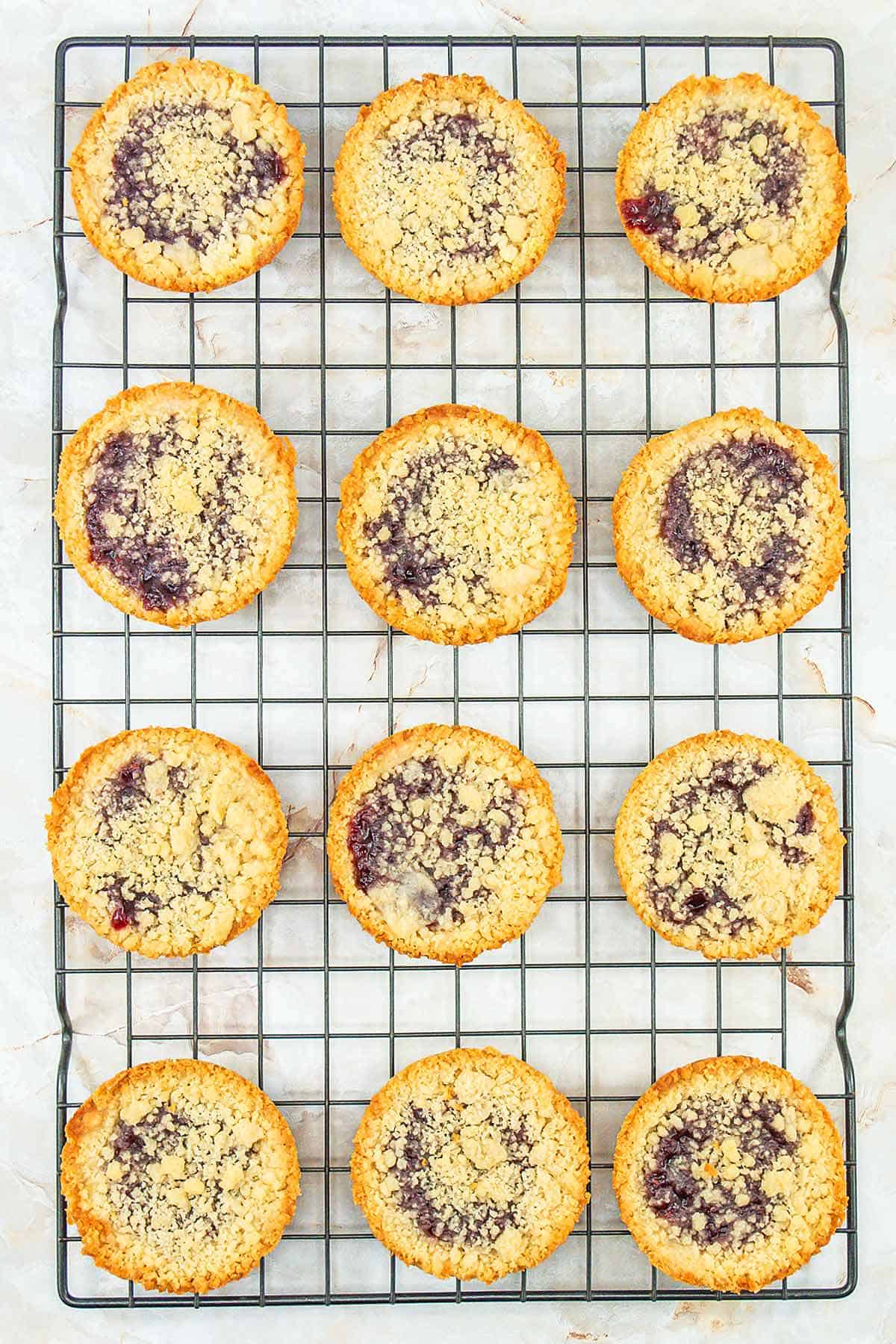 Baked raspberry crumble cookies on a wire cooling rack.