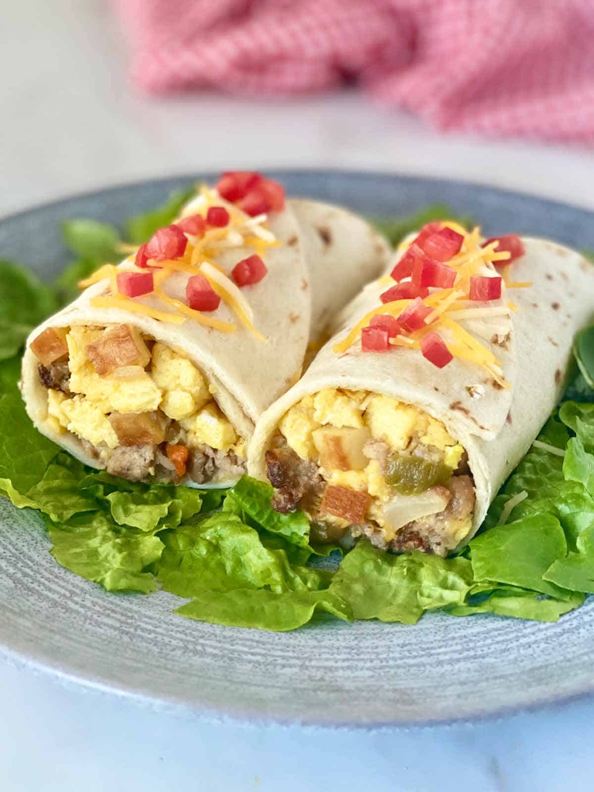 A breakfast burrito stuffed with scrambled eggs, cheese, chiles and potatoes, served on shredded lettuce.