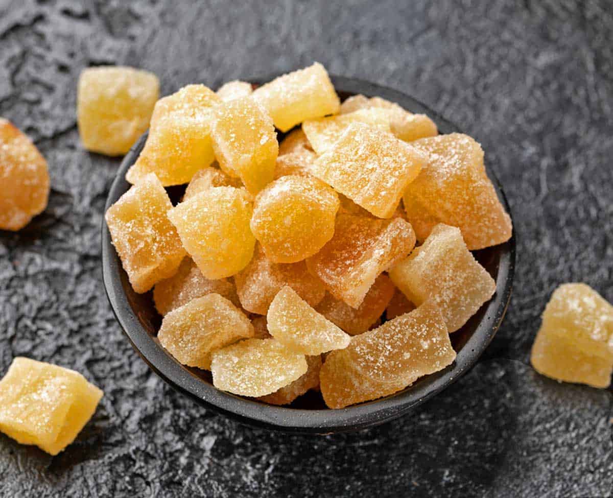 A black bowl filled with chopped candied ginger.