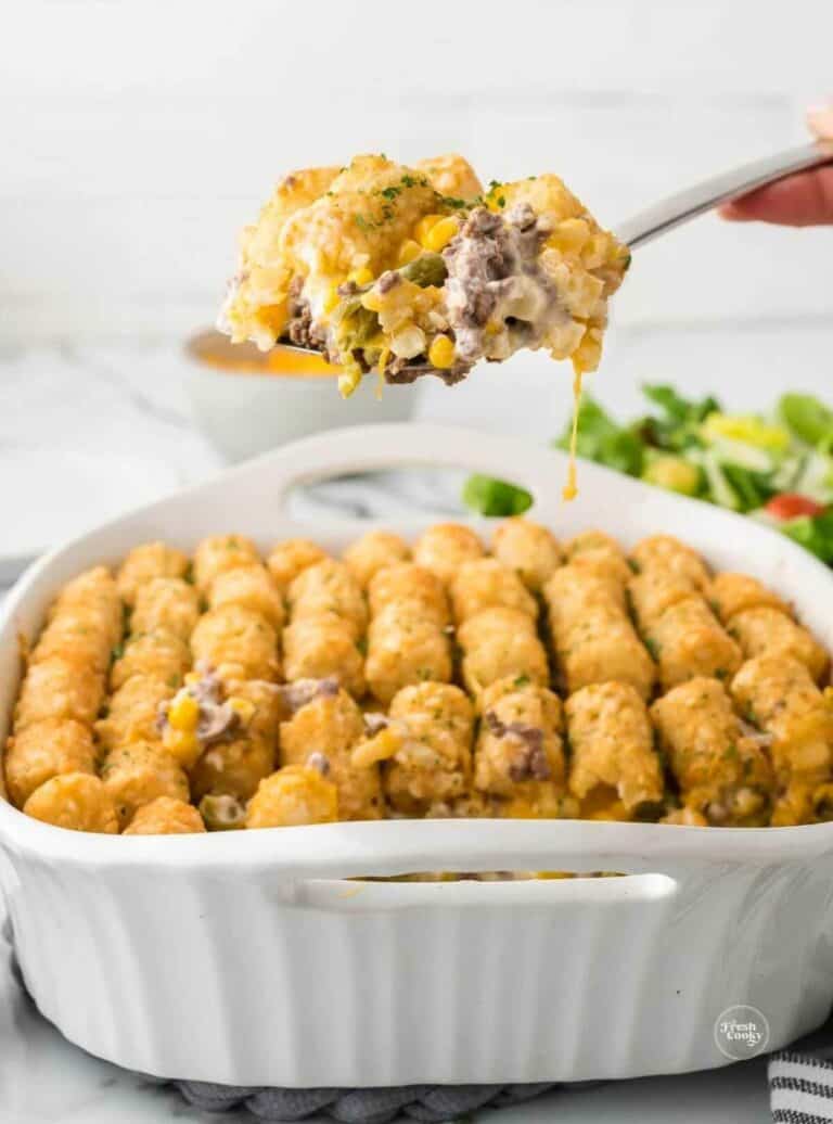 Tater tot casserole in a white serving dish.