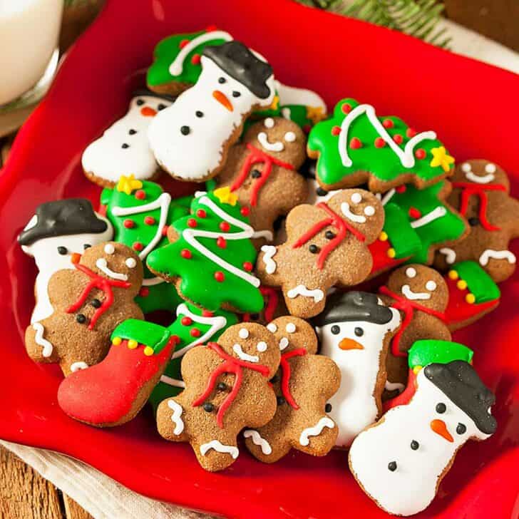 A plate of colorful frosted Christmas cookies ready to be swapped at a simple cookie exchange.