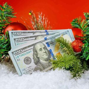 A stack of 100 dollar bills under the Christmas tree.