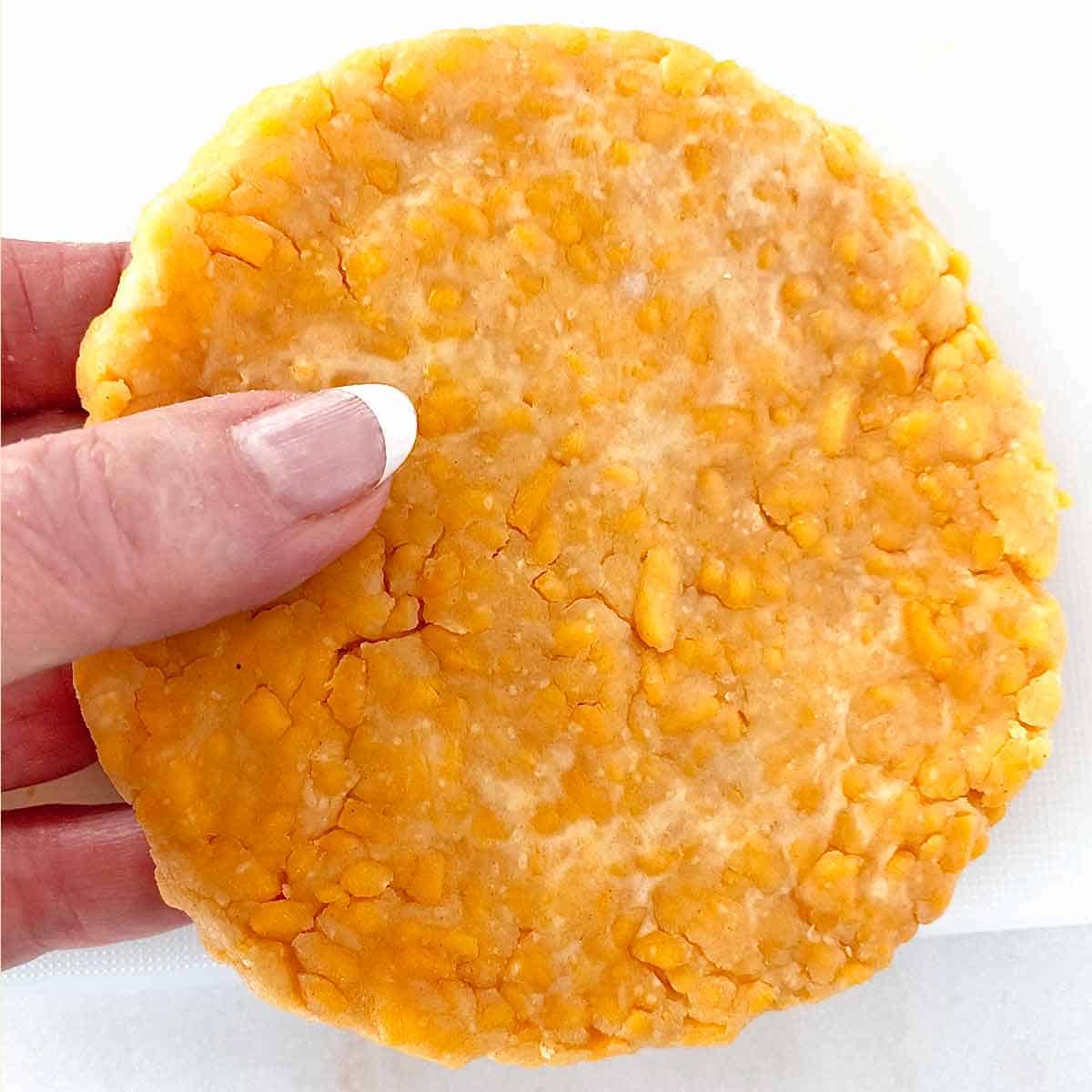 Close up of a disc of chilled dough to make cheese crackers.