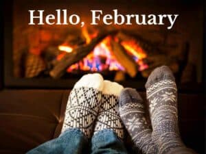 Two people wearing socks in front of a cozy fireplace.