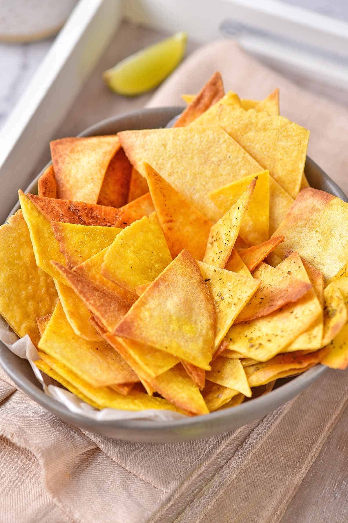 Warm homemade corn tortilla chips in a serving bowl.