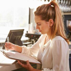 A woman reviewing her will on a clipboard.