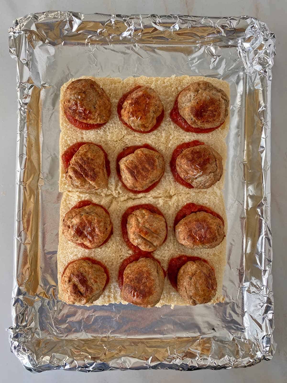 Meatballs arranged on 12 soft King's Hawaiian rolls.