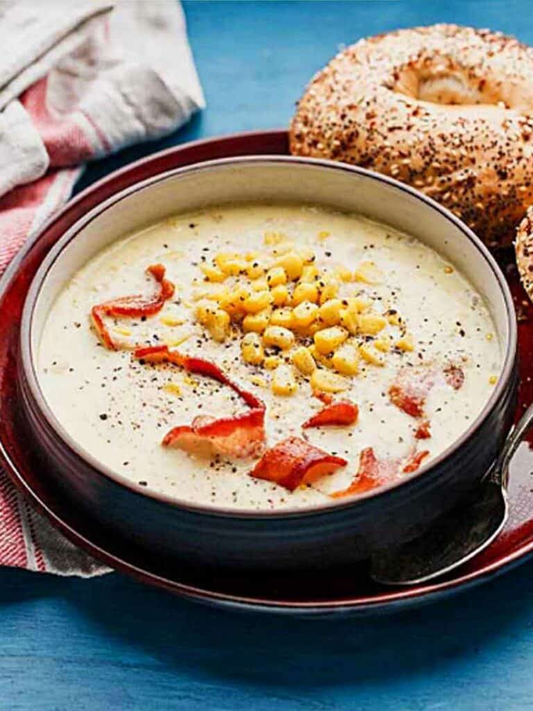 A bowl of old fashioned corn chowder topped with bacon.