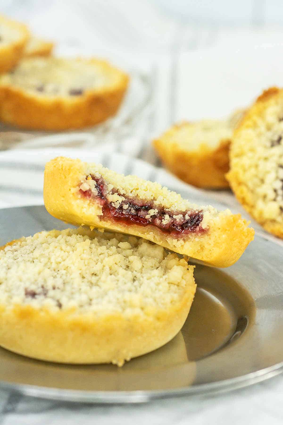 Raspberry crumb cookie with a bite taken on a silver tray.