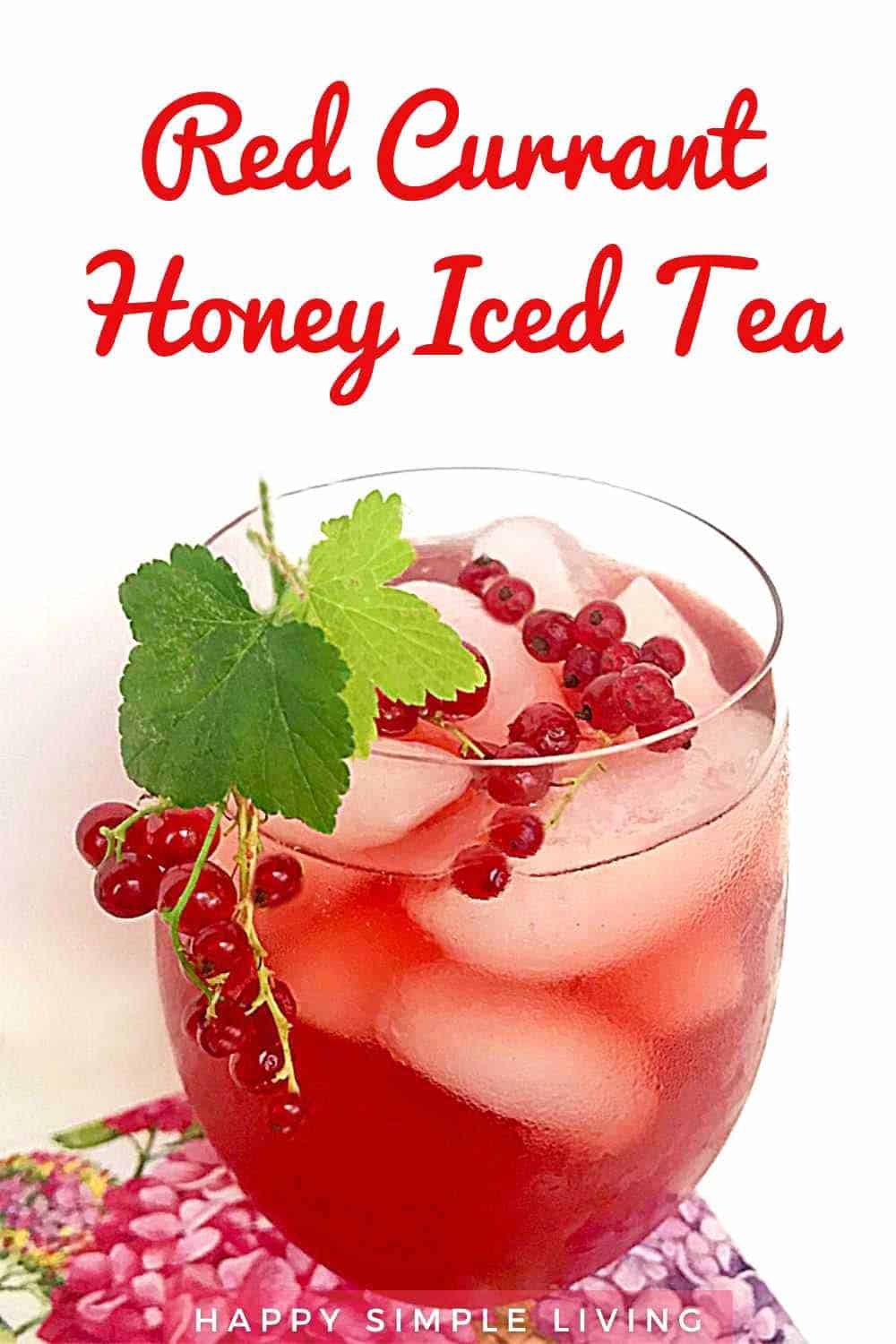 A glass of red currant honey iced tea garnished with currant leaves and berries.