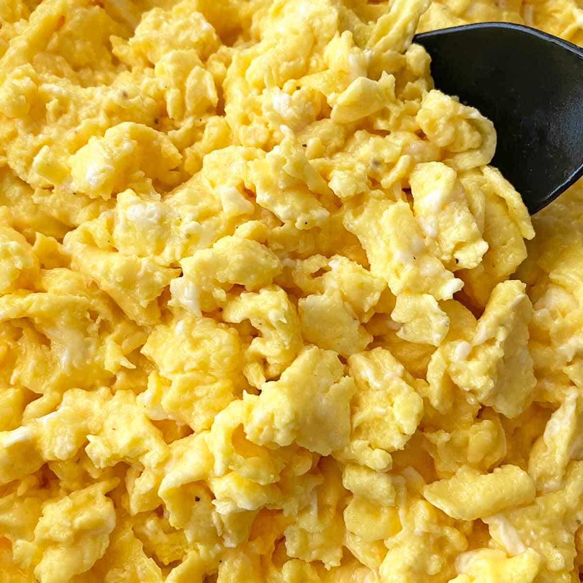 Cooking scrambled eggs in a large skillet.