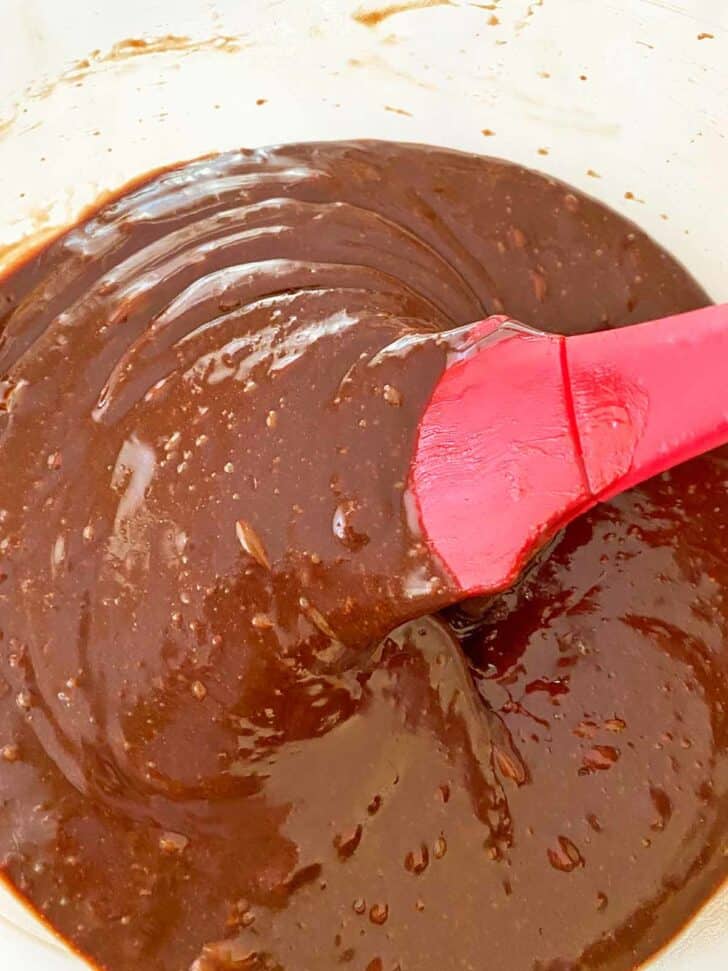 Combining chocolate cake ingredients with a spatula.