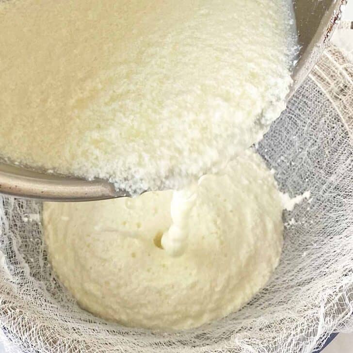 Pouring the curdled milk over the cheesecloth and strainer. 